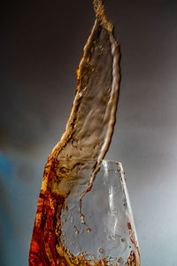Close-up of drink pouring water against white background