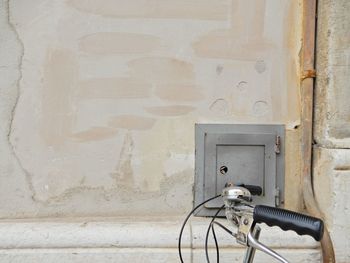 Close-up of weathered wall with part of a bicycle.