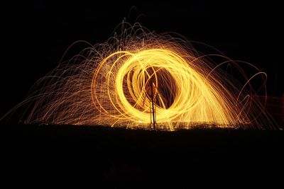 Wire wool spinning against sky at night