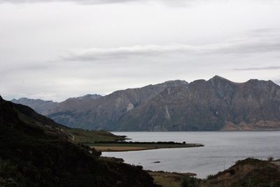 Scenic view of river and mountains against sky
