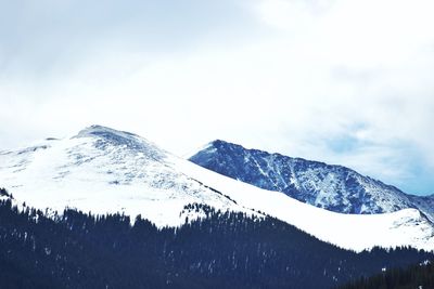 Low angle view of snowcapped mountains against sky