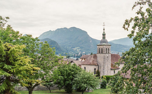 Trees in front of historic building against sky