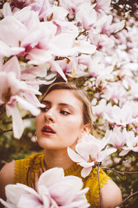 Young woman amidst pink flowers