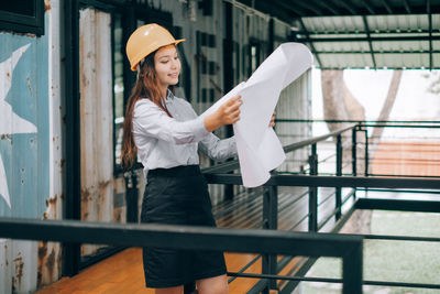 Full length of woman standing against railing