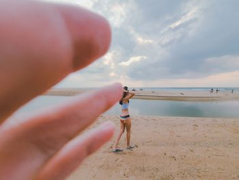 Cropped hand of woman holding sand at beach