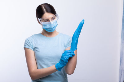 Midsection of woman holding umbrella against white background