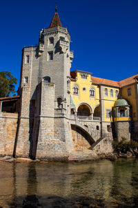 Low angle view of bridge over river against buildings