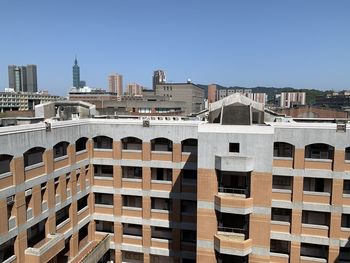 Buildings in city against clear blue sky