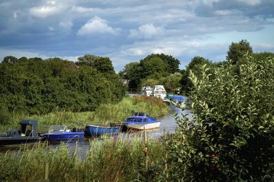 Boats moored in lake against sky