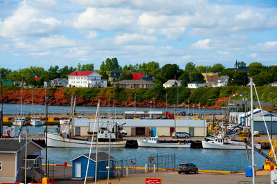 Boats moored at harbor against buildings