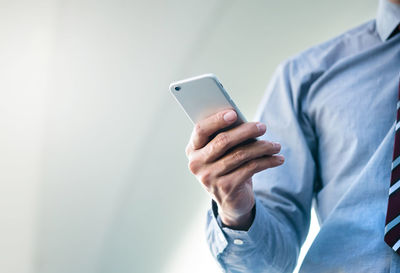 Midsection of man using mobile phone