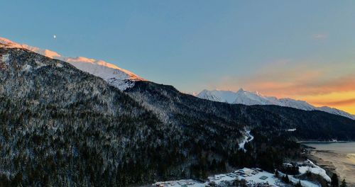 Scenic view of snowcapped mountains against sky during sunset