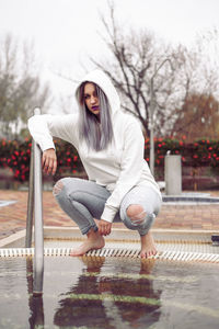 Portrait of woman sitting in rain