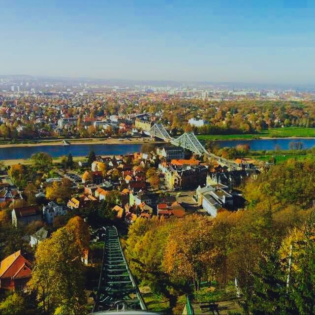 architecture, built structure, building exterior, cityscape, city, high angle view, crowded, tree, residential district, residential building, residential structure, sky, town, house, roof, townscape, river, city life, water, elevated view