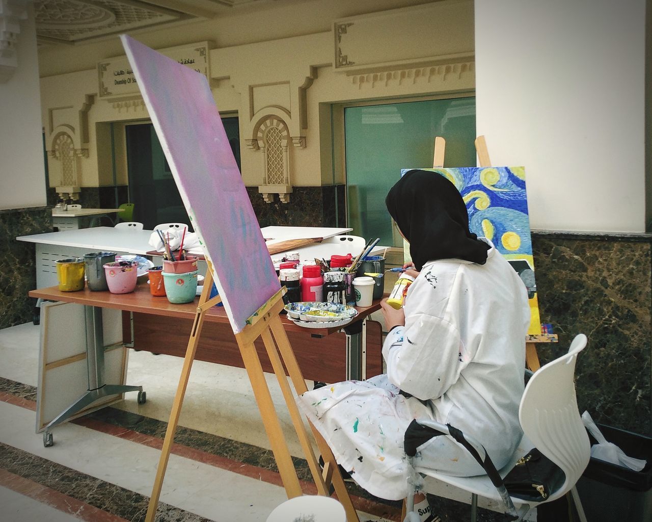 REAR VIEW OF WOMAN WORKING ON TABLE IN STADIUM