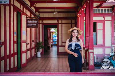 Portrait of young woman standing against the wall