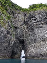 Rock formations by sea against sky