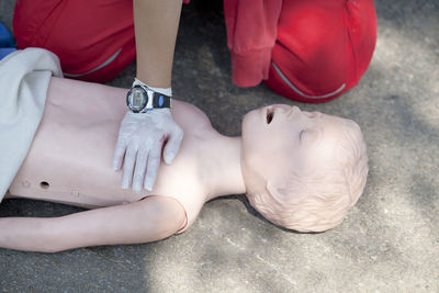 Midsection of paramedic performing cpr on dummy