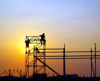 Silhouette scaffolding against sky during sunset