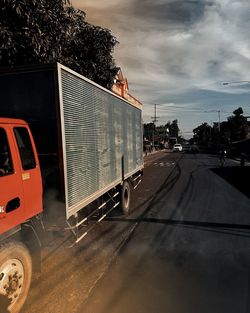 Cars on road against sky in city