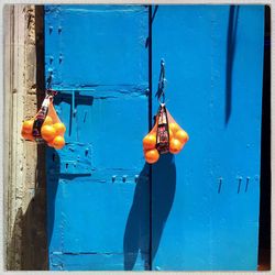 Oranges hanging on blue door