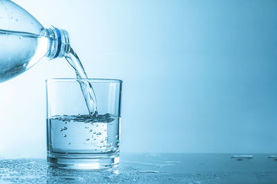 Close-up of drink in glass on table against blue background