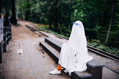Ghost waits beside train tracks wearing sunglasses