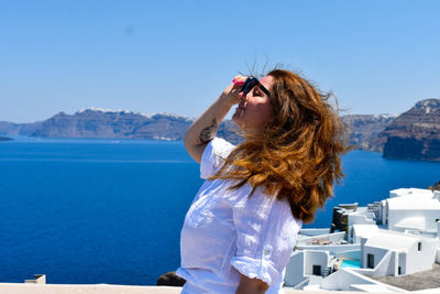 Rear view of woman looking at sea against clear sky