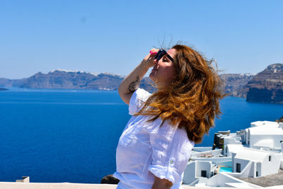 Rear view of woman looking at sea against clear sky