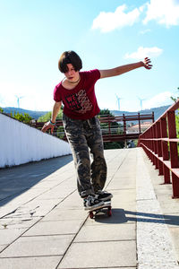 Full length of girl skateboarding on footpath