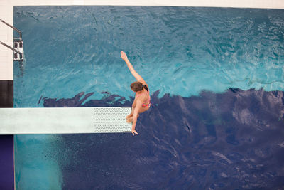 Full length of shirtless man swimming in pool