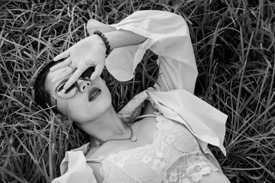 High angle view of beautiful young woman lying on grass