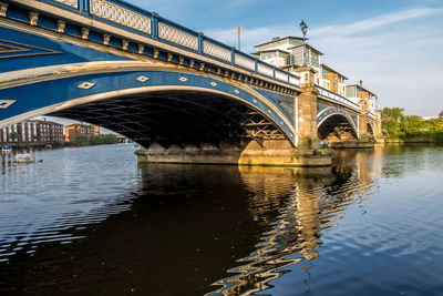 Arch bridge over river against sky