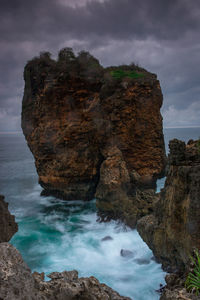 Rocks in sea against sky