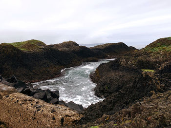 Rocks in sea against sky