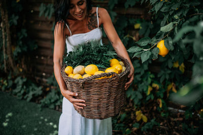 Young woman holding fruits in basket