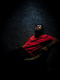 Rear view of man sitting on floor