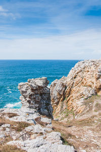 Rock formations by sea against sky