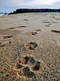 Close-up of sand on beach against sky