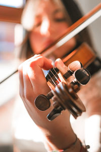 Close-up of woman playing violin at home