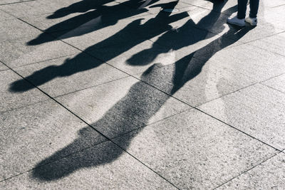 Low section of person standing on footpath in city