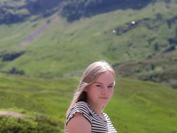 Portrait of young woman against landscape