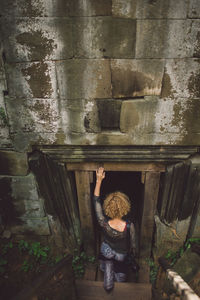 Rear view of woman entering in old ruin