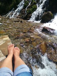 Low section of person in waterfall