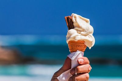 Cropped hand holding ice cream cone