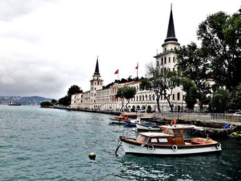 Sailboats in river with buildings in background