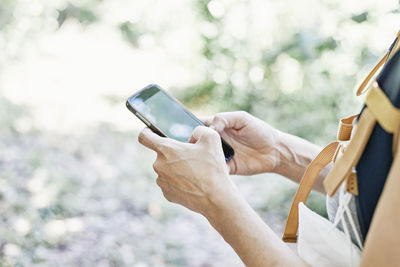 Midsection of person photographing with mobile phone