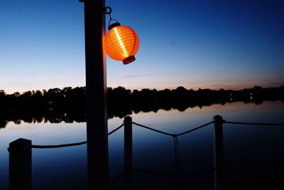 Reflection of tree in lake against sky during sunset