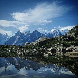 Scenic view of lake by mountains against sky