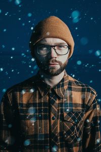 Portrait of young man wearing hat against gray background